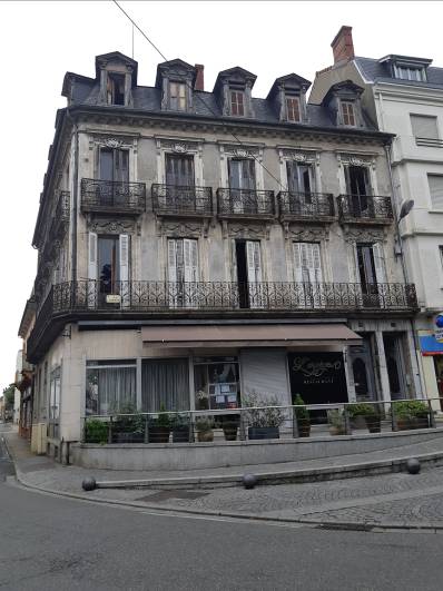 Immeuble ancien de 3 &eacute;tages avec une fa&ccedil;ade grise, avec un magasin en rez-de-chauss&eacute;e, avant sa r&eacute;novation