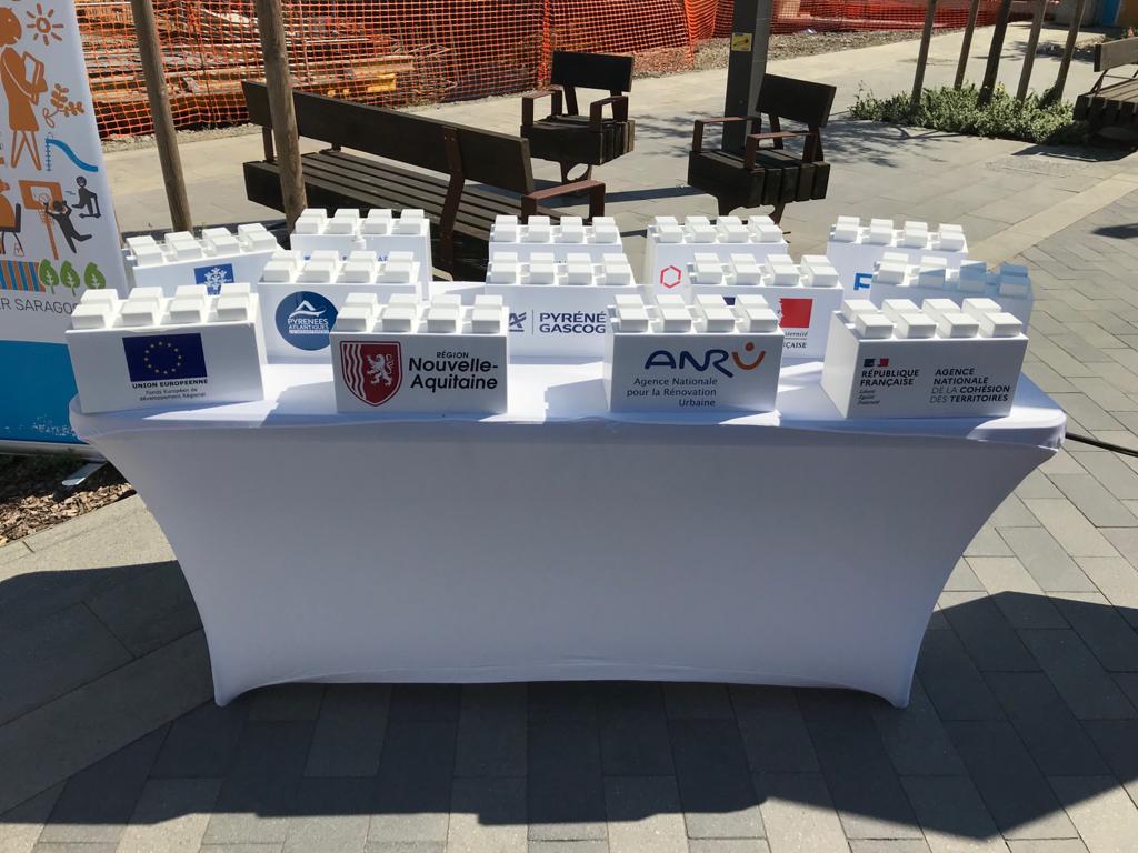 Sur une table, logos des investisseurs mont&eacute;s sur de gros logos blancs. 