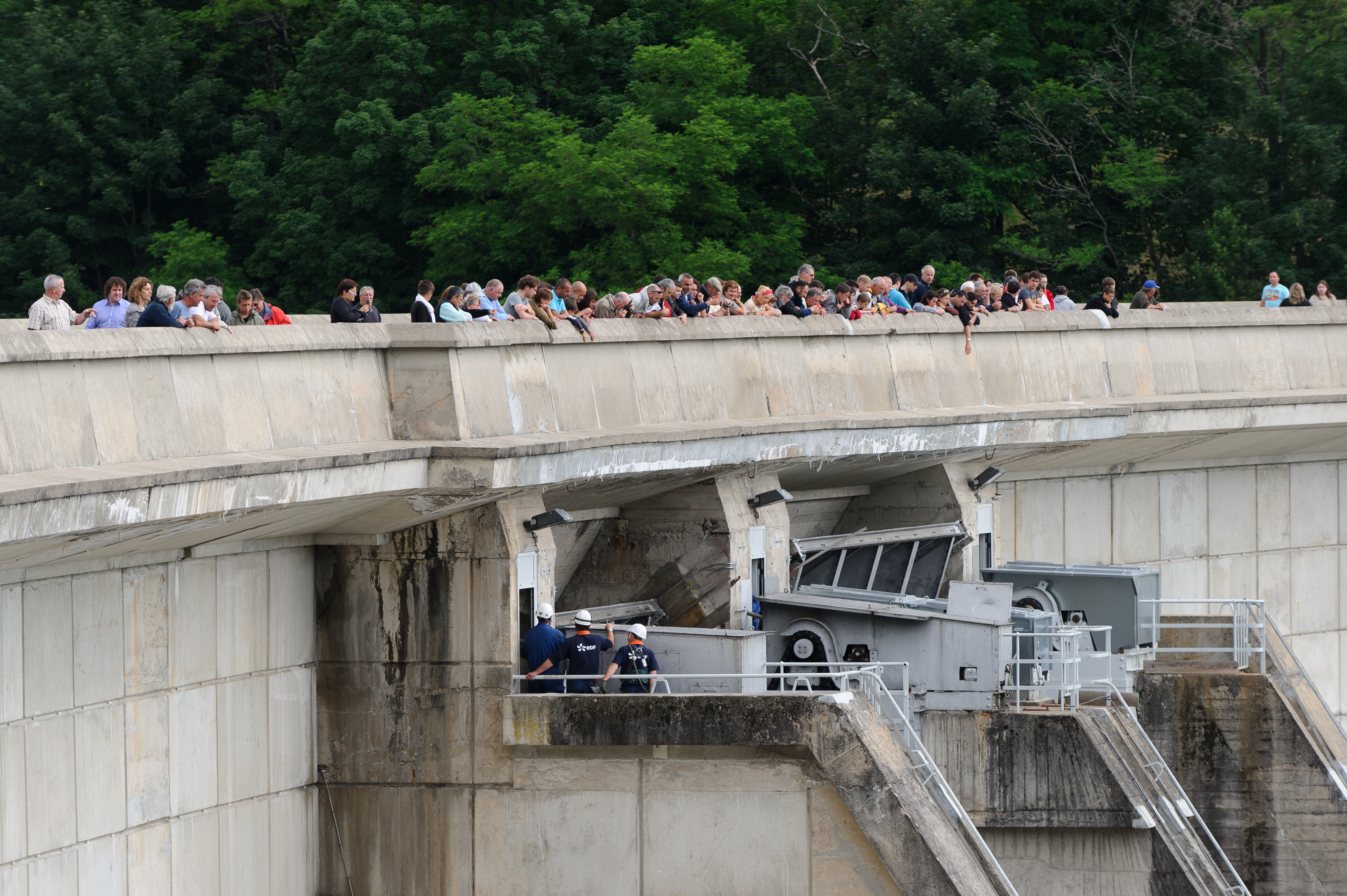 Des visiteurs regardent des ouvriers EDF intervenir sur le barrage de Bort-les-Orgues, dans le Cantal