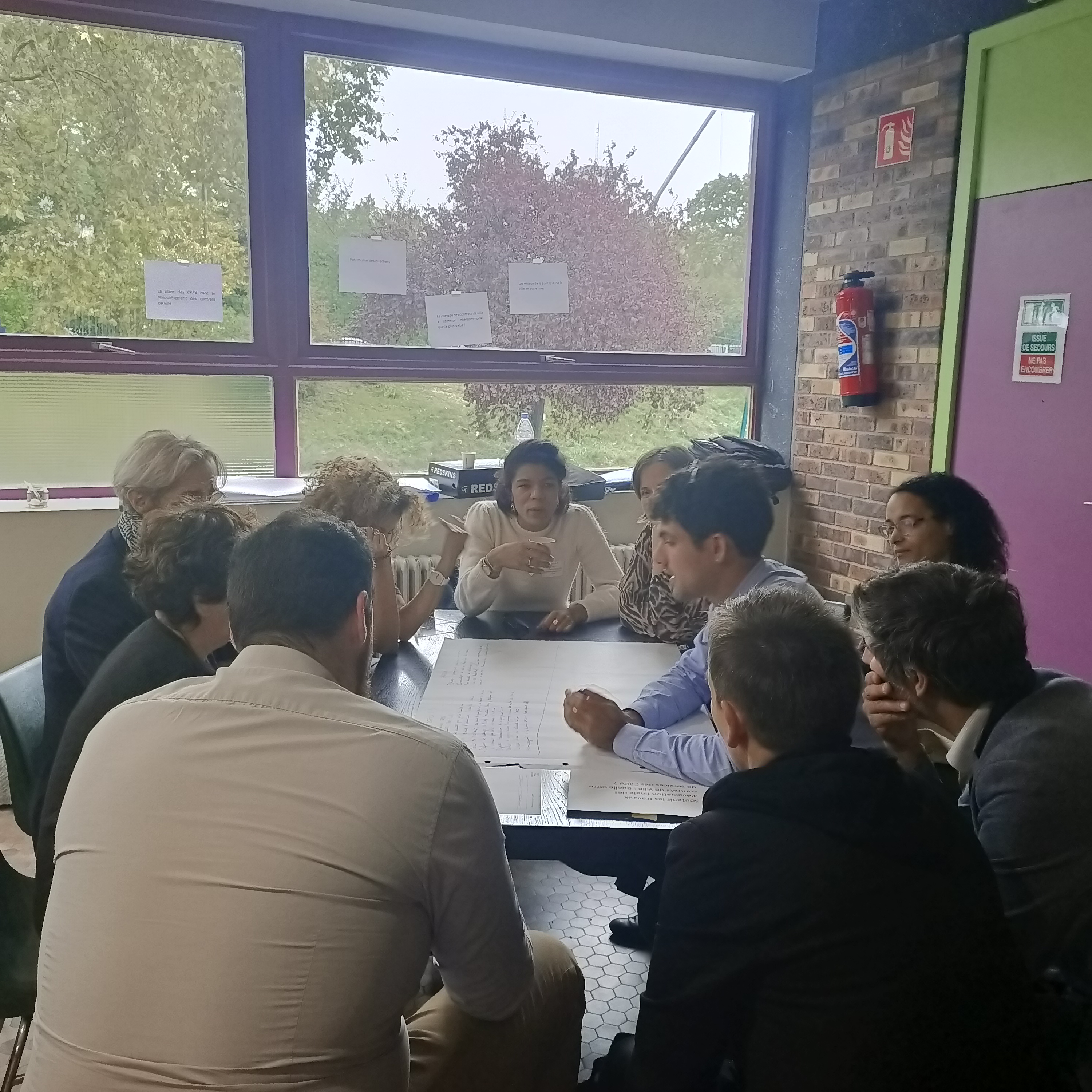 Personnes en atelier de travail, réparties autour d'une table