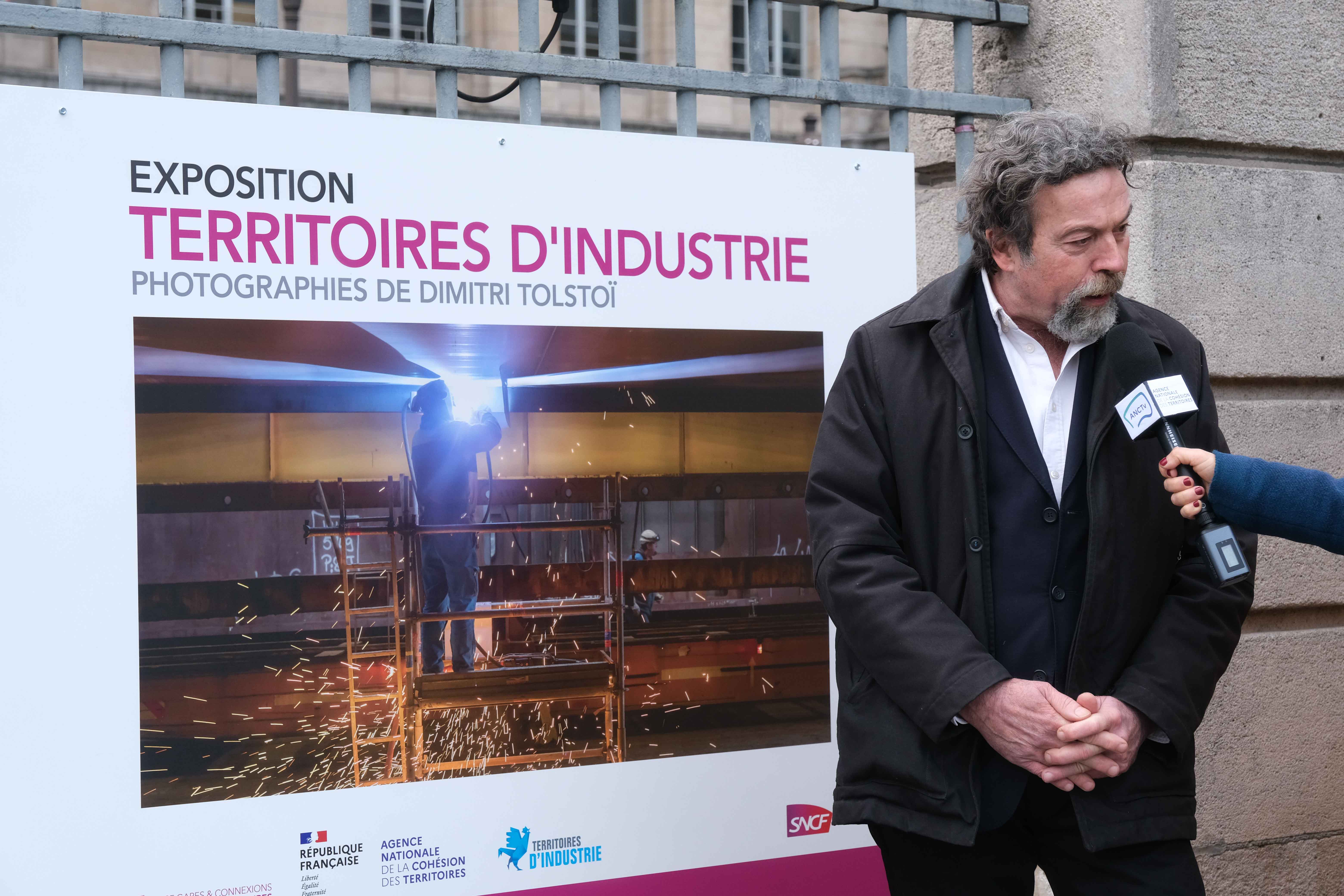 Le photographe interviwé devant l'une de ses photos.