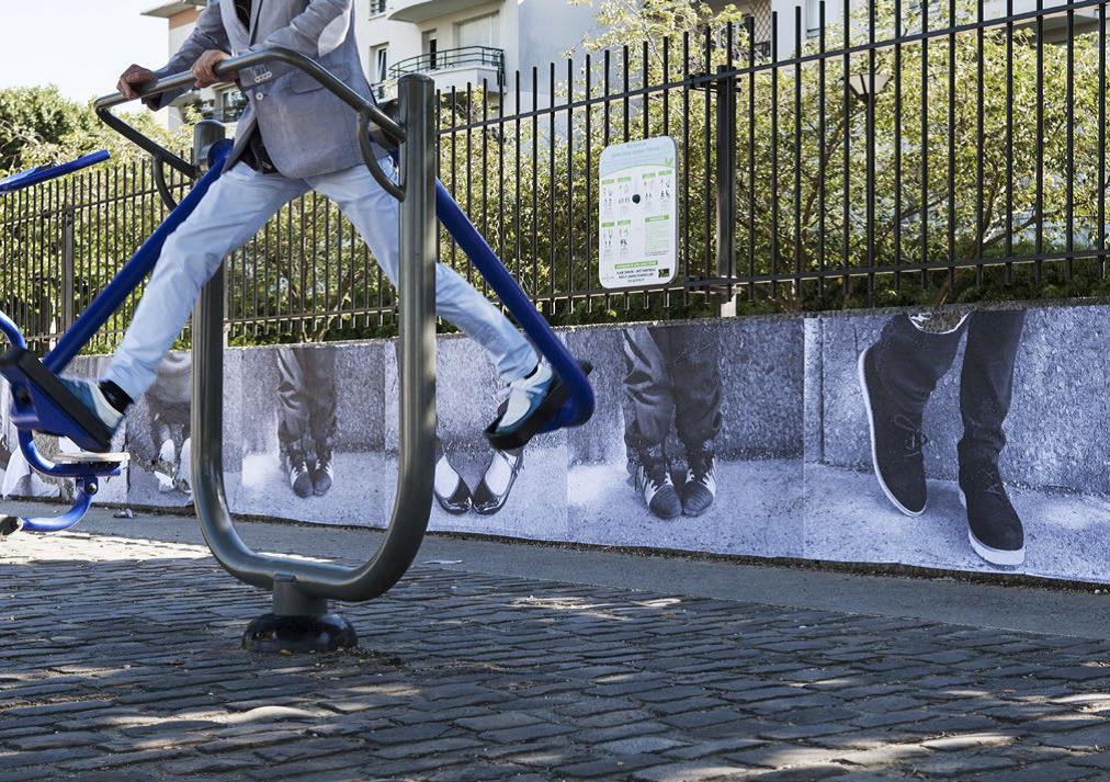Vue sur les jambes d'une personne qui fait de l'exercice physique sur un agrès installé dans un espace public extérieur.