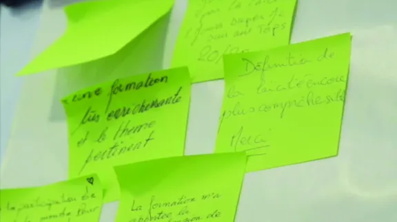 Photo de post-it jaunes coll&eacute;s &agrave; un mur avec des commentaires des personnes form&eacute;es
