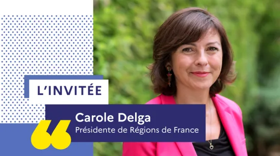 Portrait de Carole Delga, souriante, en veste rose et chemisier noir.